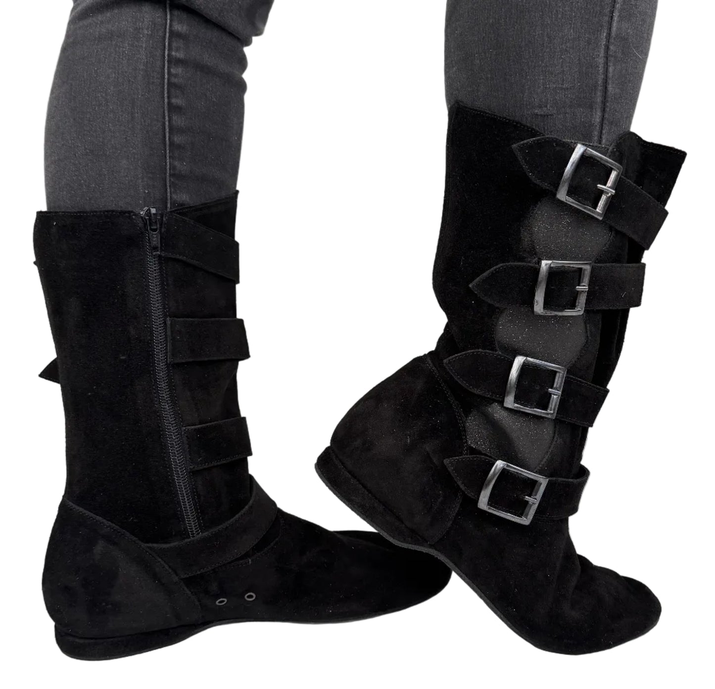 Black knee-high boots with buckles worn by a person on a light gray background