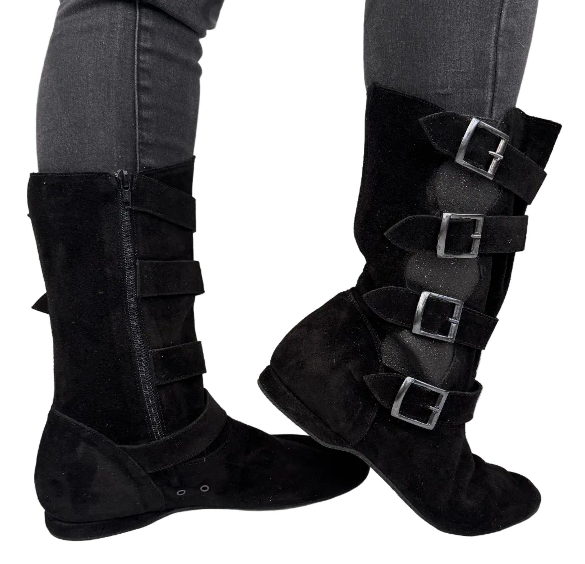 Black knee-high boots with buckles worn by a person on a light gray background